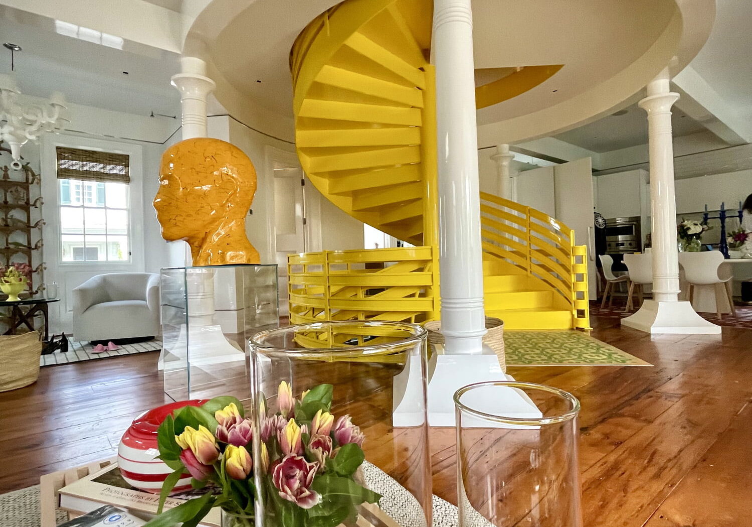 A yellow luxurious staircase in the center of a restored Davis Academy House